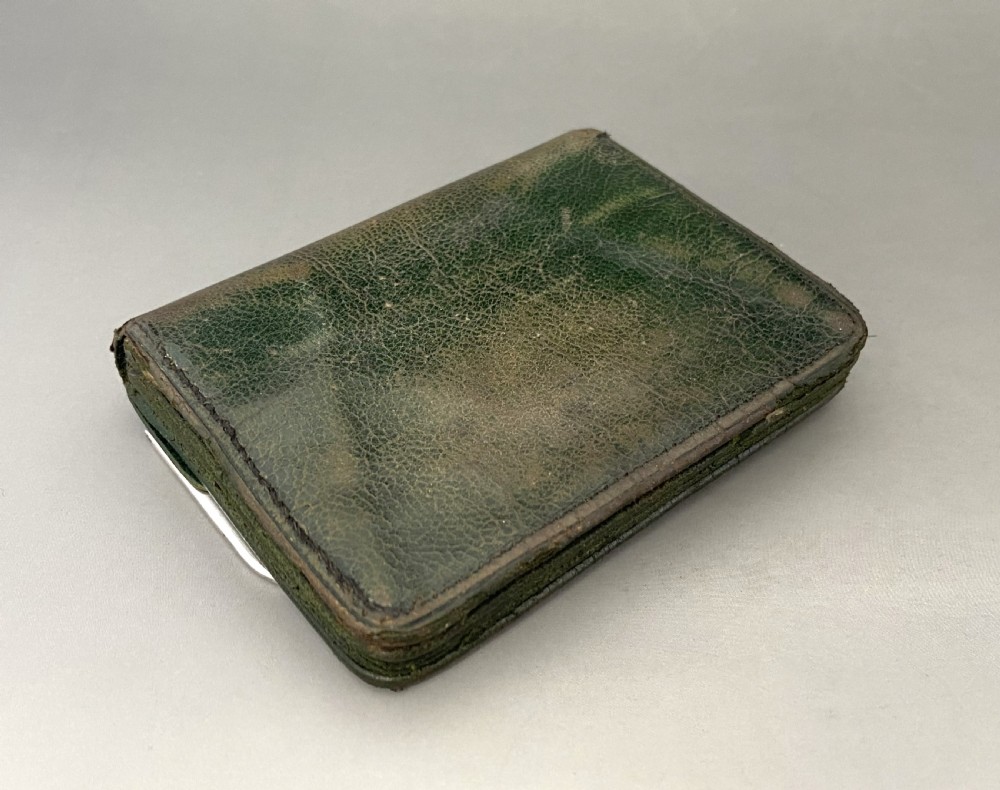 A dark green leather purse featuring intricate silver Art Nouveau corner mounts and a central silver clasp. View V