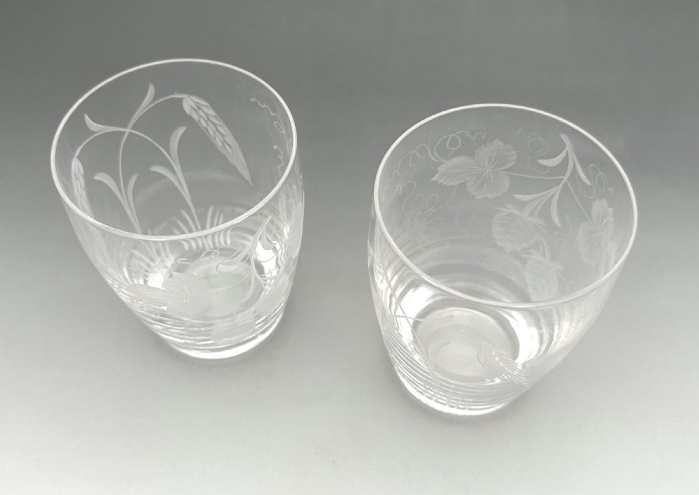 A pair of clear glass tumblers decorated with wheel-engraved botanical motifs depicting hops and barley. View V