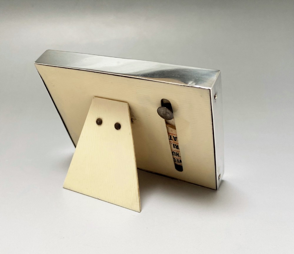 An Art Deco perpetual desk calendar framed in silver with a tortoiseshell border surrounding a central grid displaying printed numbers and days of the week. View III