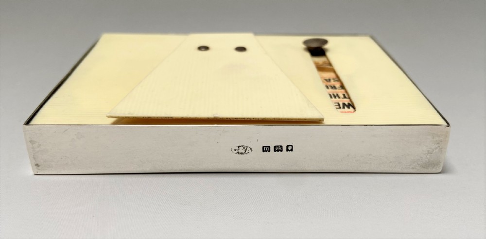 An Art Deco perpetual desk calendar framed in silver with a tortoiseshell border surrounding a central grid displaying printed numbers and days of the week. View IV