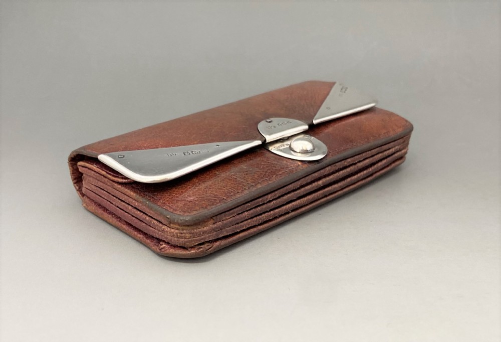 An Edwardian brown leather purse featuring hallmarked sterling silver corner mounts and a central silver clasp fastener. View III