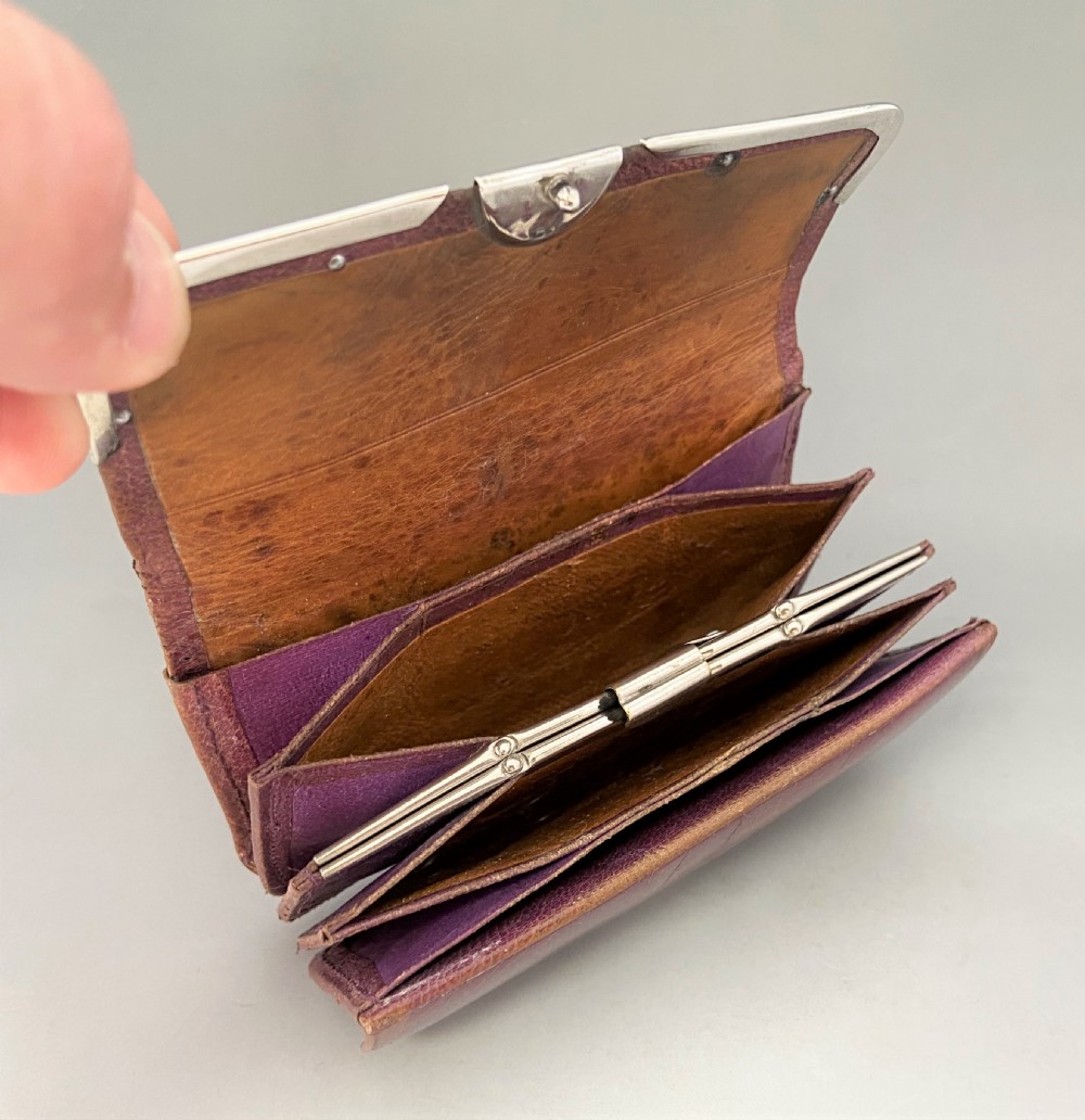 An Edwardian brown leather purse featuring hallmarked sterling silver corner mounts and a central silver clasp fastener. View IV