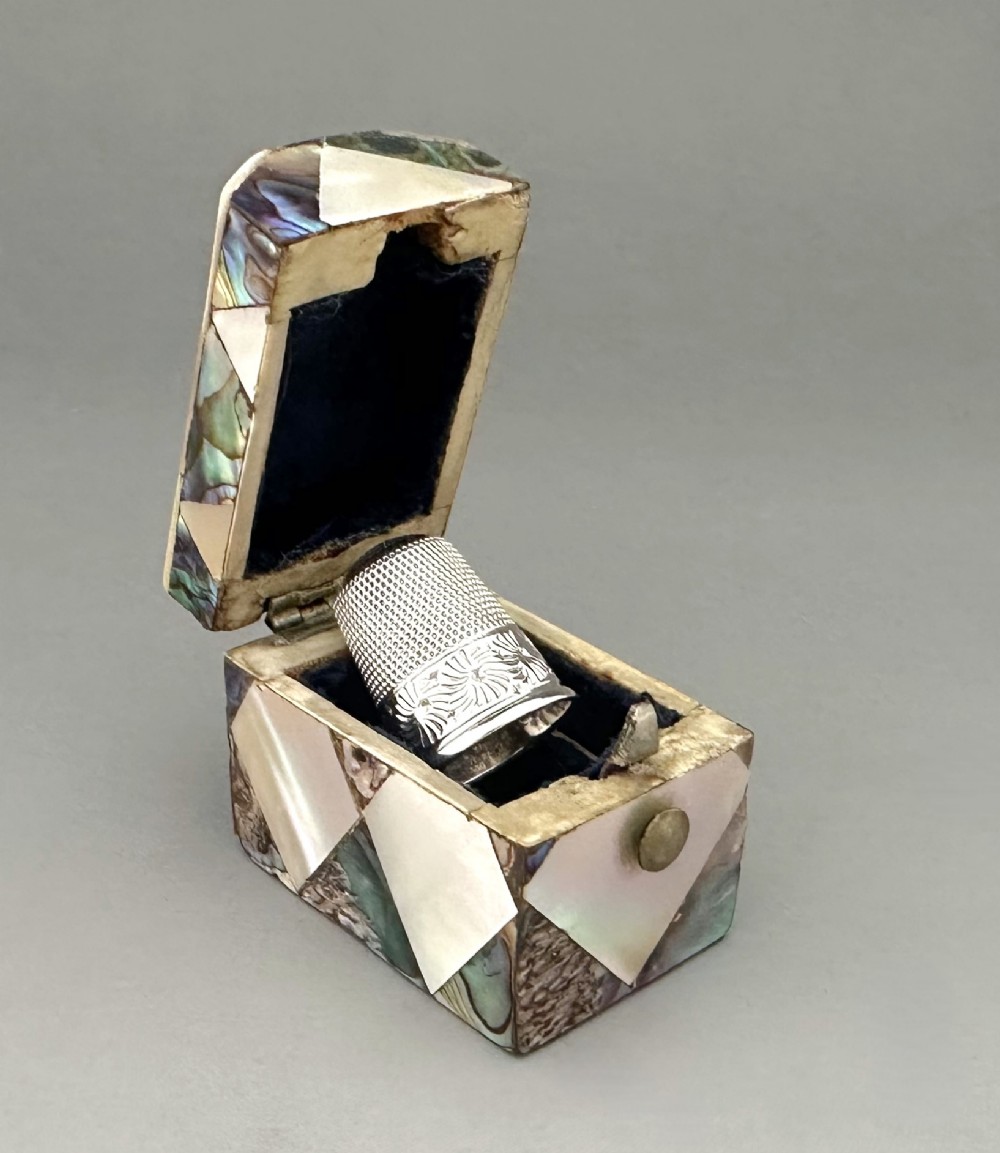 A delightful Victorian mother-of-pearl thimble box & silver thimble