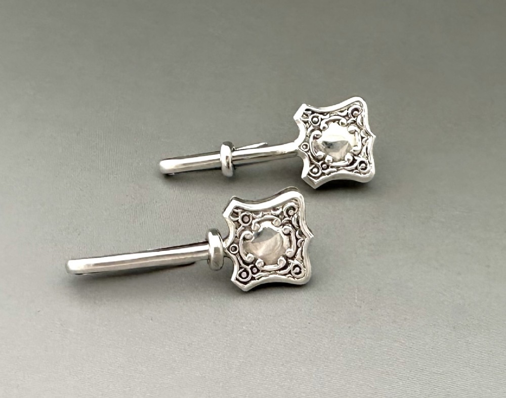 A useful pair of George VI silver napkin clips