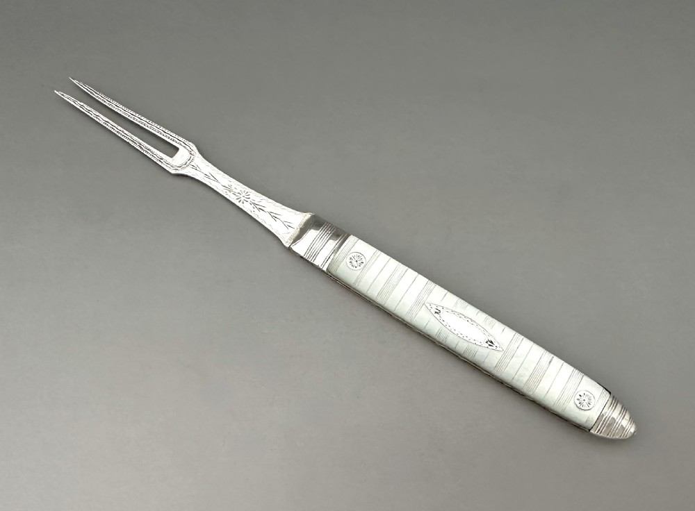A late eighteenth-century silver folding fruit fork featuring engraved two-pronged tines and a decorated mother-of-pearl handle on a neutral background.