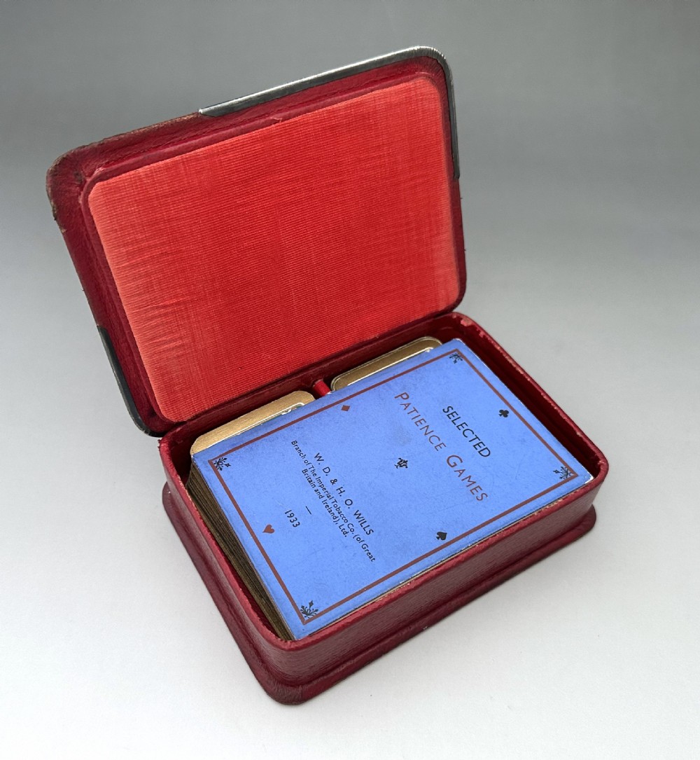 A rectangular red textured leather card box featuring silver corner mounts and silver script reading Patience across the top. View VI