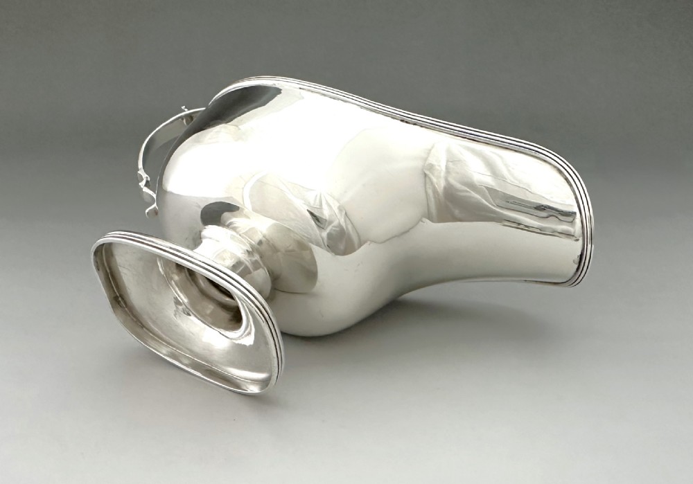 A George V sterling silver sauce boat featuring a scroll handle, extended pouring spout, and pedestal foot base. View VI