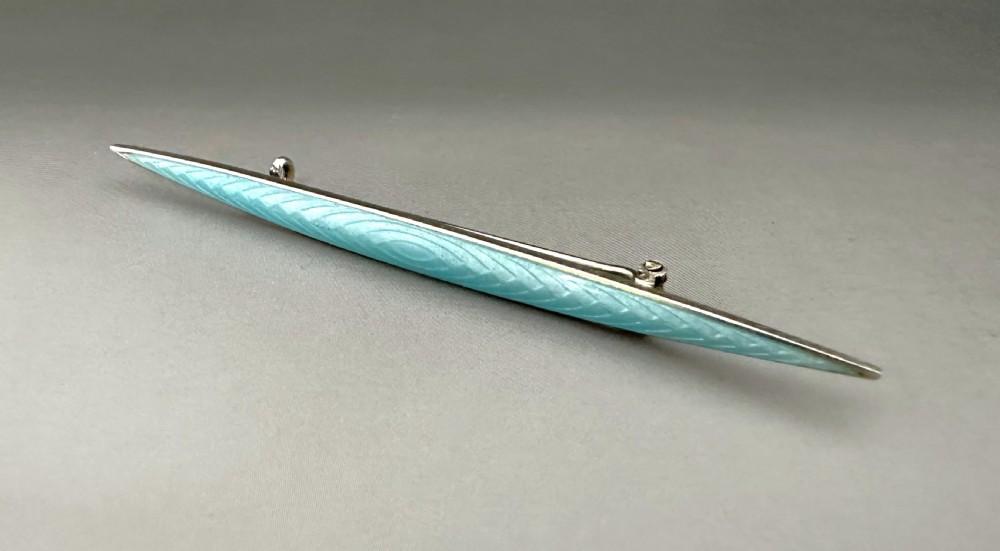 A slender Norwegian sterling silver bar brooch featuring light turquoise guilloche vitreous enamel over an engine-turned pattern. View II