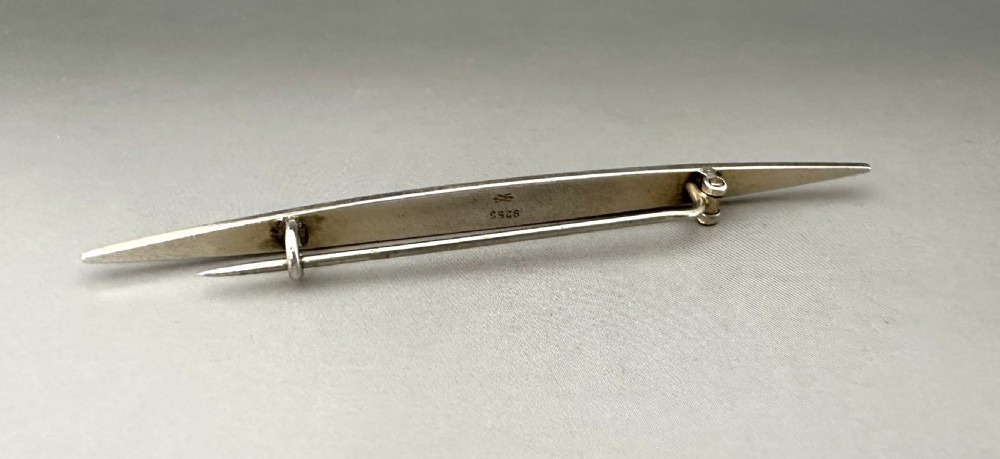 A slender Norwegian sterling silver bar brooch featuring light turquoise guilloche vitreous enamel over an engine-turned pattern. View III