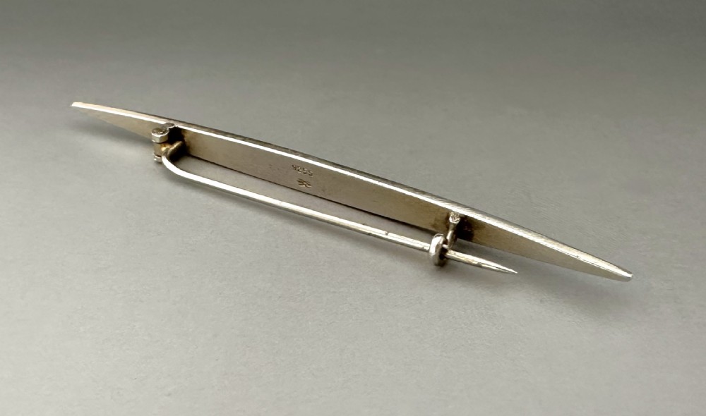 A slender Norwegian sterling silver bar brooch featuring light turquoise guilloche vitreous enamel over an engine-turned pattern. View V