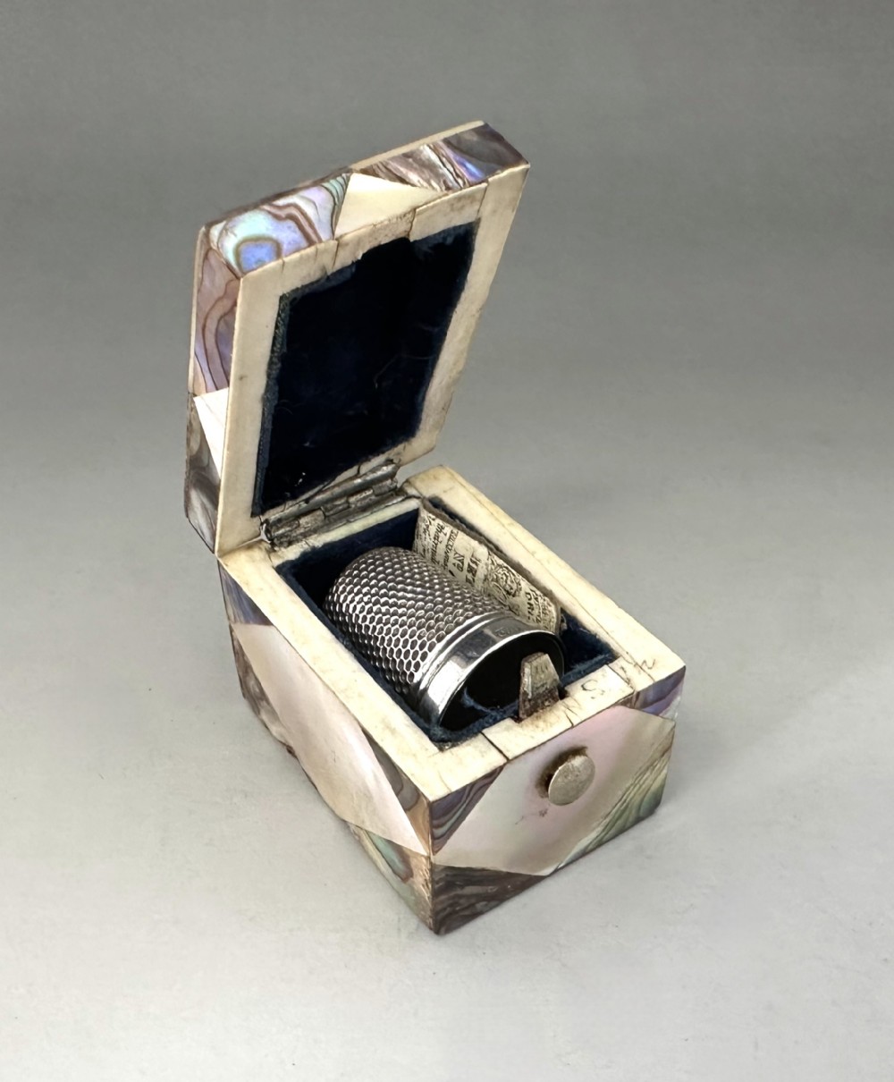 A delightful Victorian mother-of-pearl thimble box & silver thimble