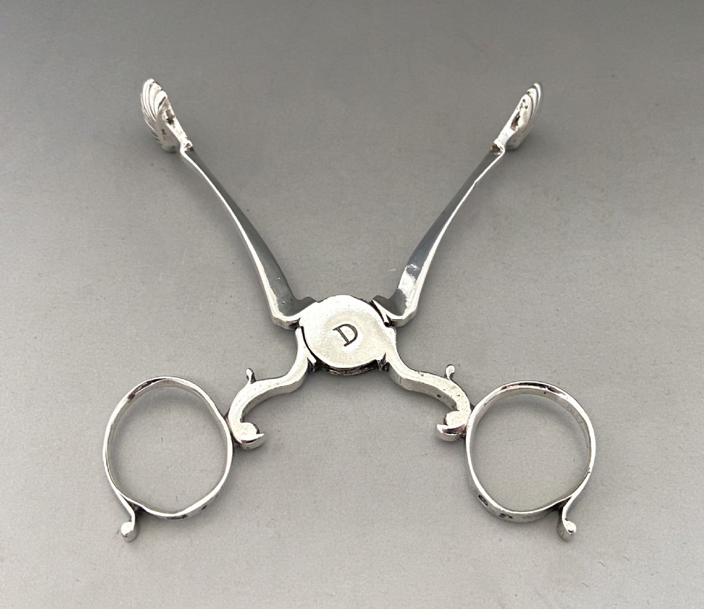 A pair of 18th-century silver scissor-action sugar nips with shell-shaped grips and an engraved monogram on the central pivot. View III