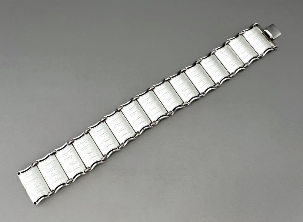 A Scandinavian sterling silver panel bracelet decorated with white guilloche enamel and dark contrasting borders. View X