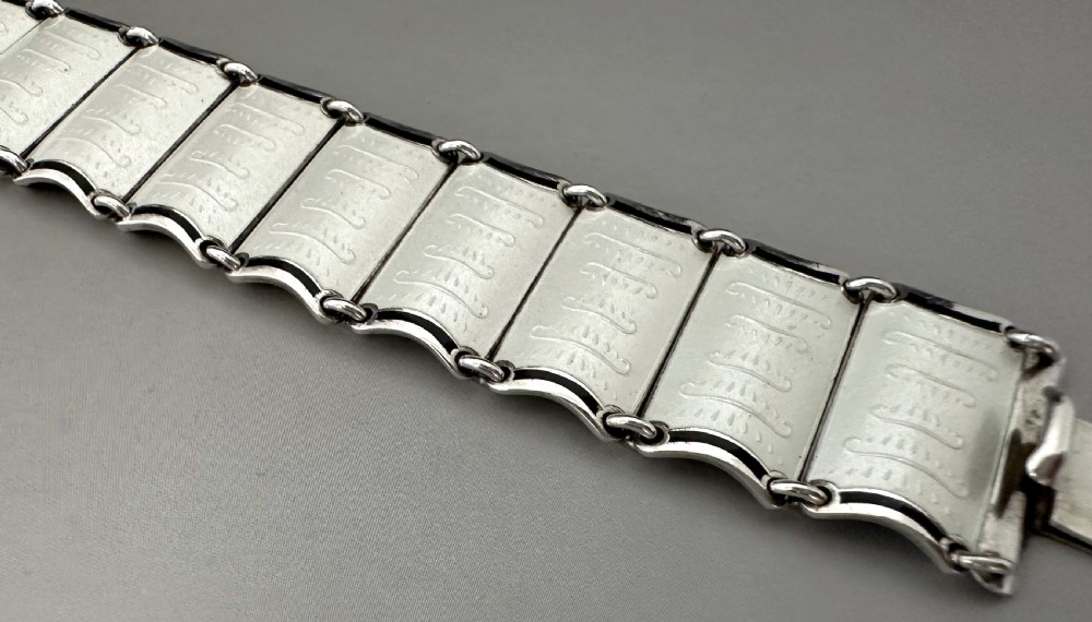 A Scandinavian sterling silver panel bracelet decorated with white guilloche enamel and dark contrasting borders. View VI