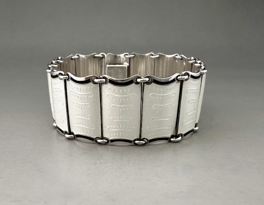 A Scandinavian sterling silver panel bracelet decorated with white guilloche enamel and dark contrasting borders.