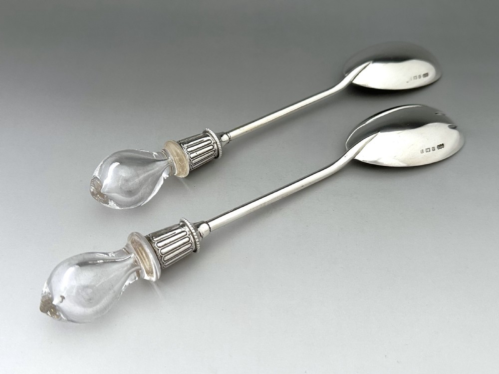 A pair of Edwardian silver salad servers featuring a rounded spoon and a three-pronged fork with decorative fluted ferrules and clear glass drop handles. View II