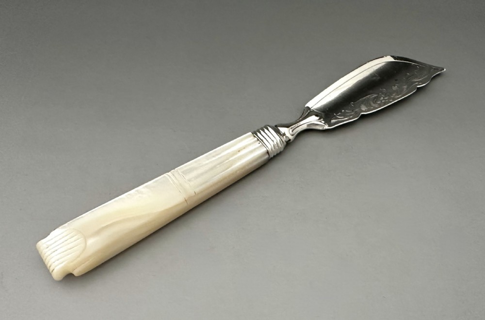 A Victorian silver butter knife featuring an engraved foliate blade and a carved mother-of-pearl handle. View III