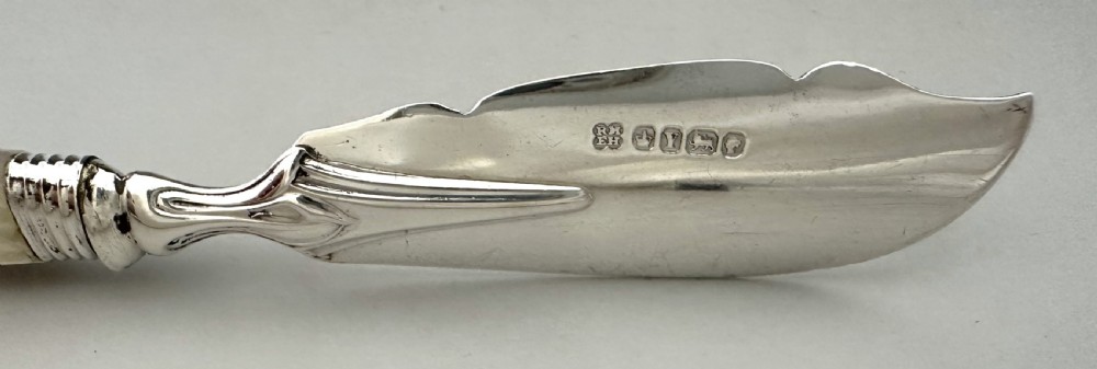 A Victorian silver butter knife featuring an engraved foliate blade and a carved mother-of-pearl handle. View IV