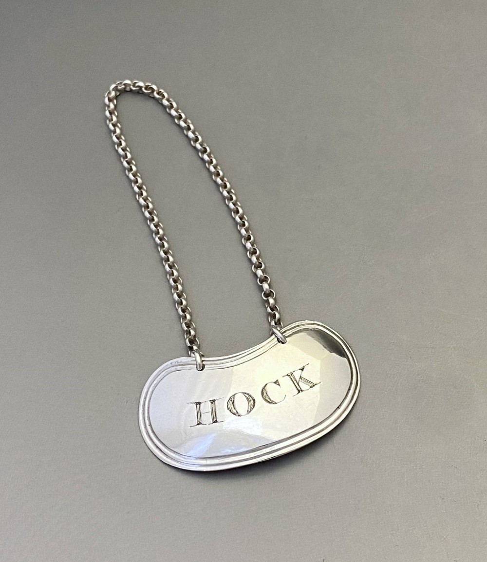 A Georgian sterling silver decanter label engraved with the word HOCK suspended from a fine silver chain.