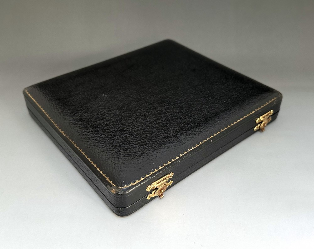 A cased set of six sterling silver cake forks and a central serving fork arranged in a black velvet-lined presentation box with a cream silk lid lining. View XI