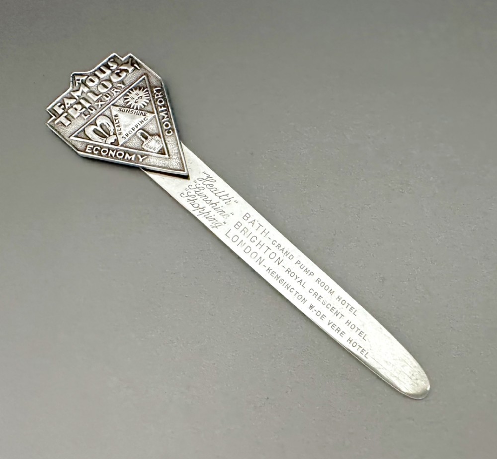 An Art Deco silver novelty advertising bookmark featuring an embossed crest and an engraved flat stem detailing historic English hotels.
