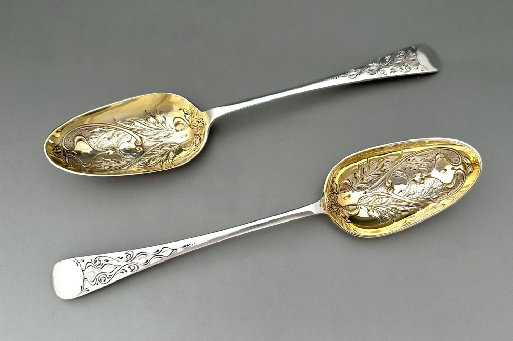 A pair of Art Nouveau sterling silver serving spoons with engraved foliate bowls and gold gilding, displayed in a red fitted velvet case. View III