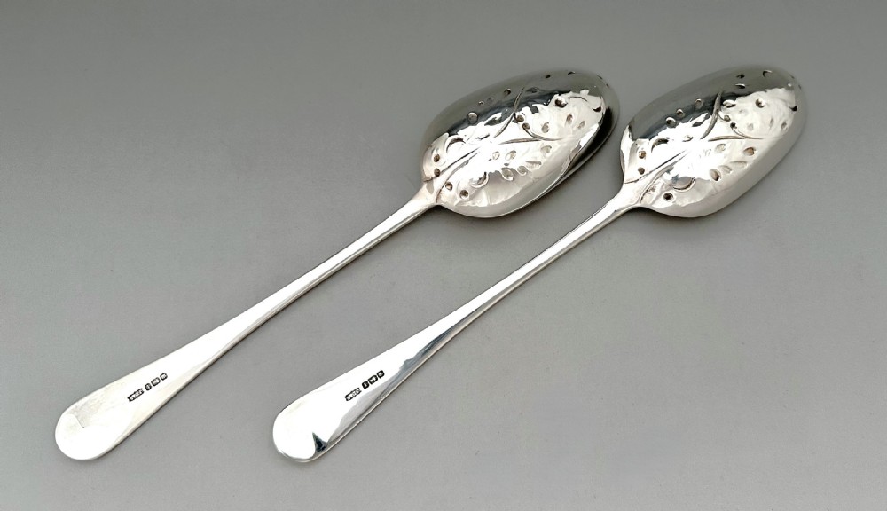 A pair of Art Nouveau sterling silver serving spoons with engraved foliate bowls and gold gilding, displayed in a red fitted velvet case. View VI
