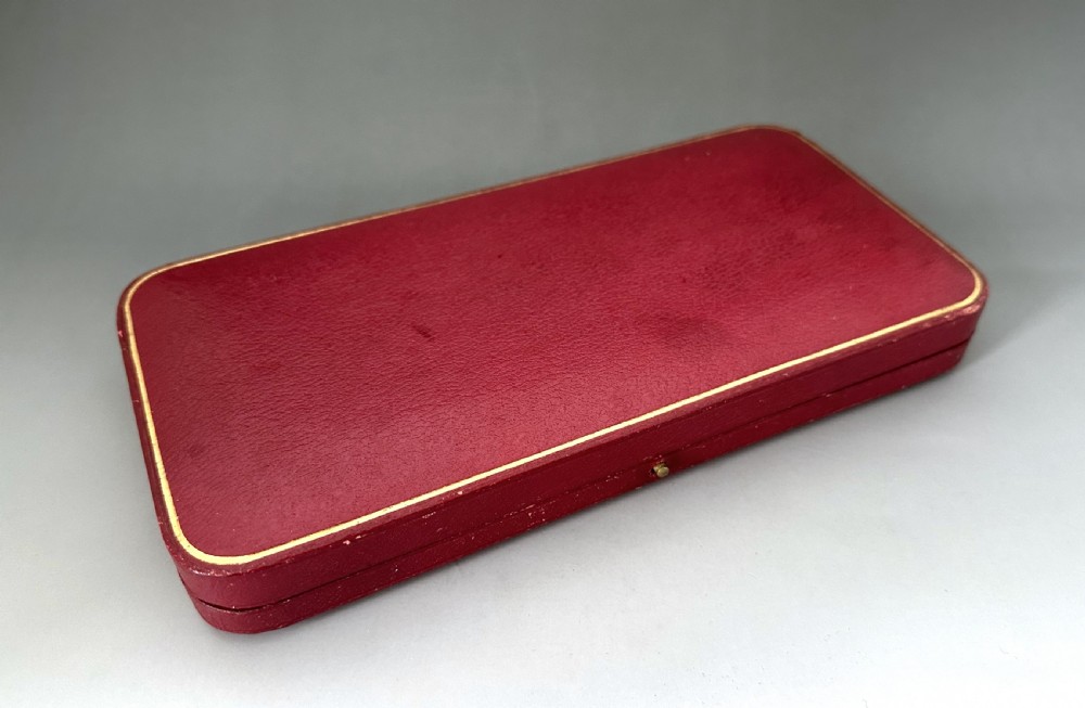 A pair of Art Nouveau sterling silver serving spoons with engraved foliate bowls and gold gilding, displayed in a red fitted velvet case. View VIII