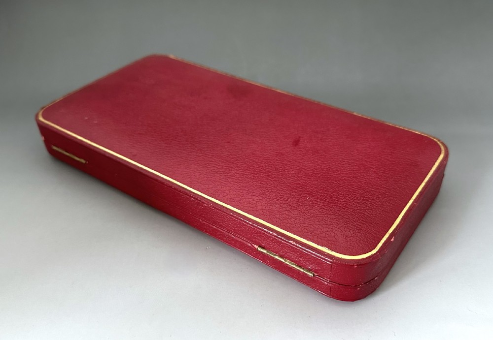A pair of Art Nouveau sterling silver serving spoons with engraved foliate bowls and gold gilding, displayed in a red fitted velvet case. View IX