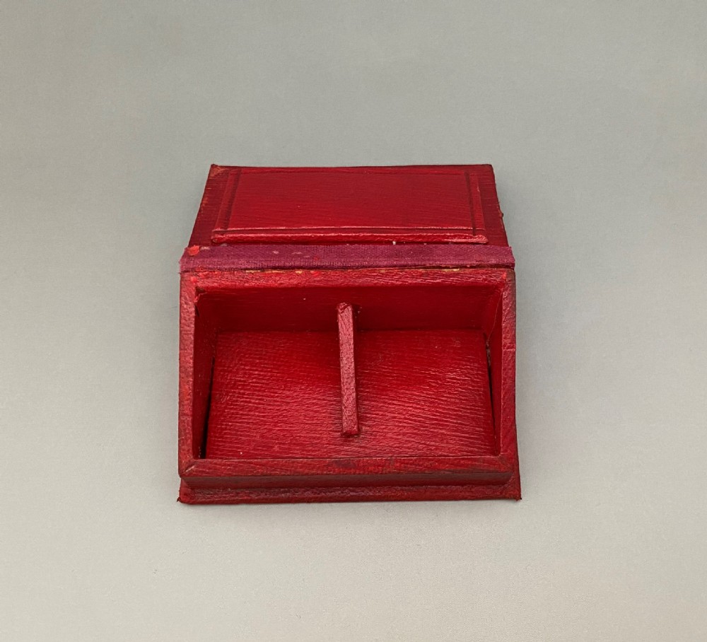 An Edwardian sterling silver double stamp box featuring a decorative gadrooned border, two glazed top panels displaying Edward VII stamps, and a red leather base. View VI