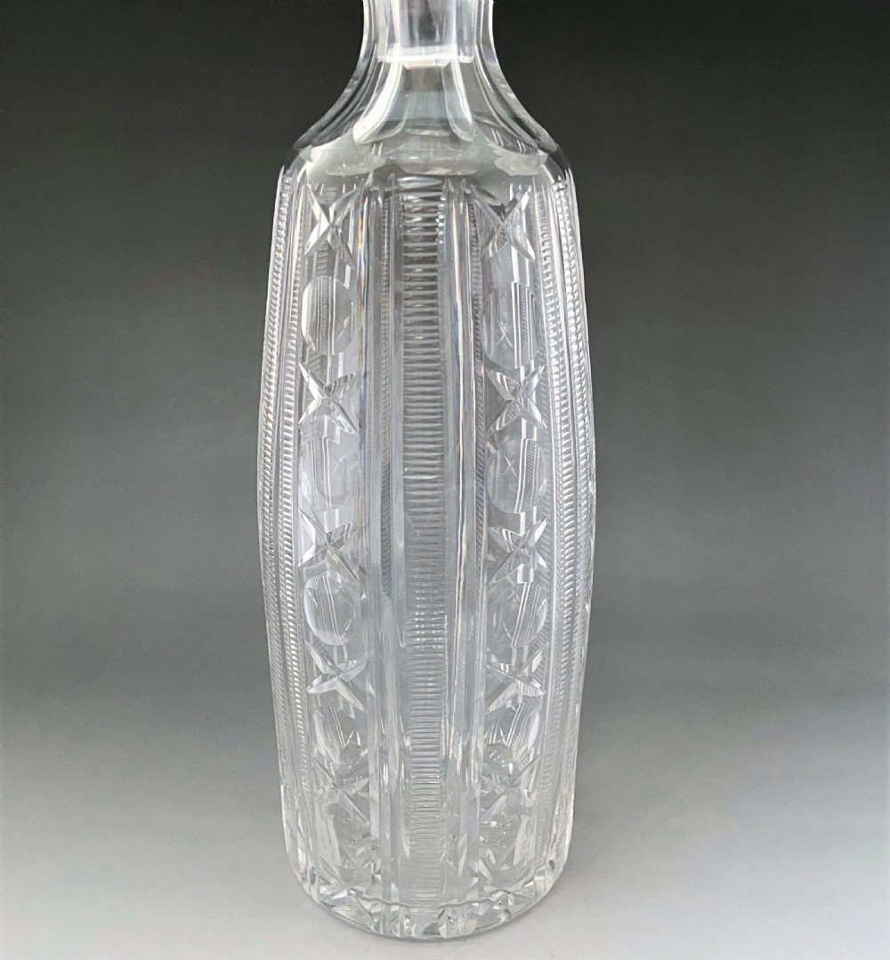 A tall clear Victorian cut glass decanter featuring geometric star and diamond pattern cuttings with a fitted faceted glass stopper. View IV