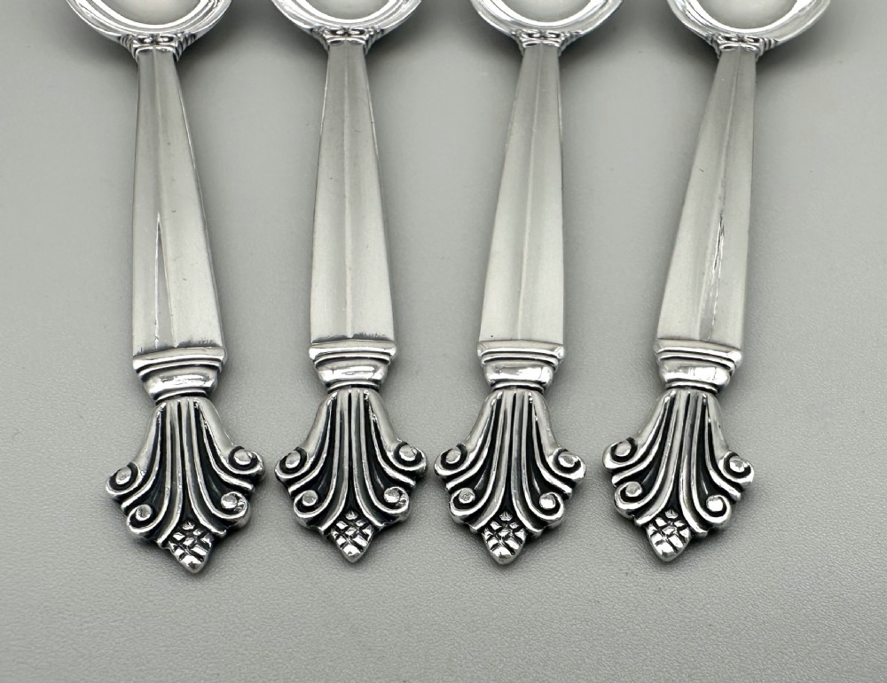 A set of four Danish sterling silver teaspoons with decorative carved scroll handles. View IV