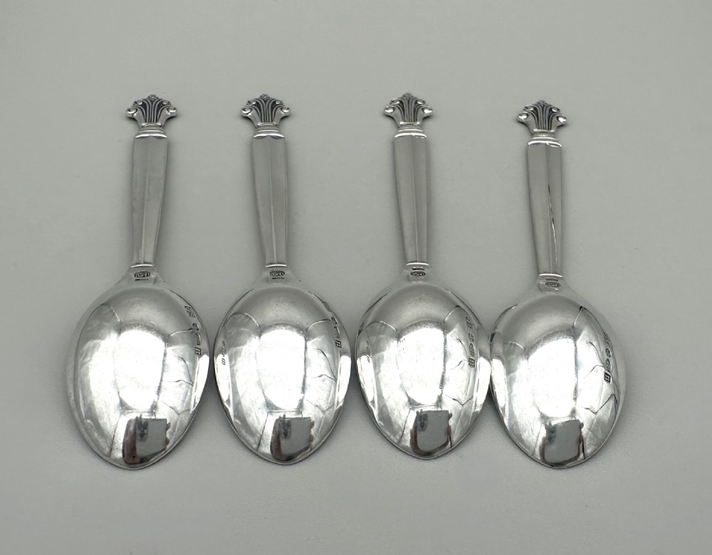 A set of four Danish sterling silver teaspoons with decorative carved scroll handles. View V