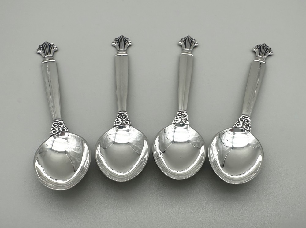 A set of four Danish sterling silver teaspoons with decorative carved scroll handles. View VI