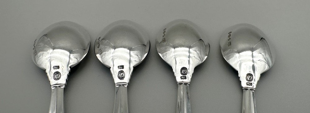 A set of four Danish sterling silver teaspoons with decorative carved scroll handles. View VIII