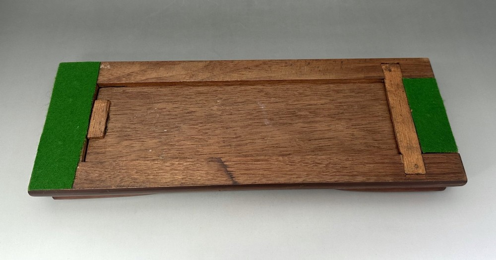 An extended wooden Victorian book slide with brass strapwork end panels holding a row of antique books. View VI