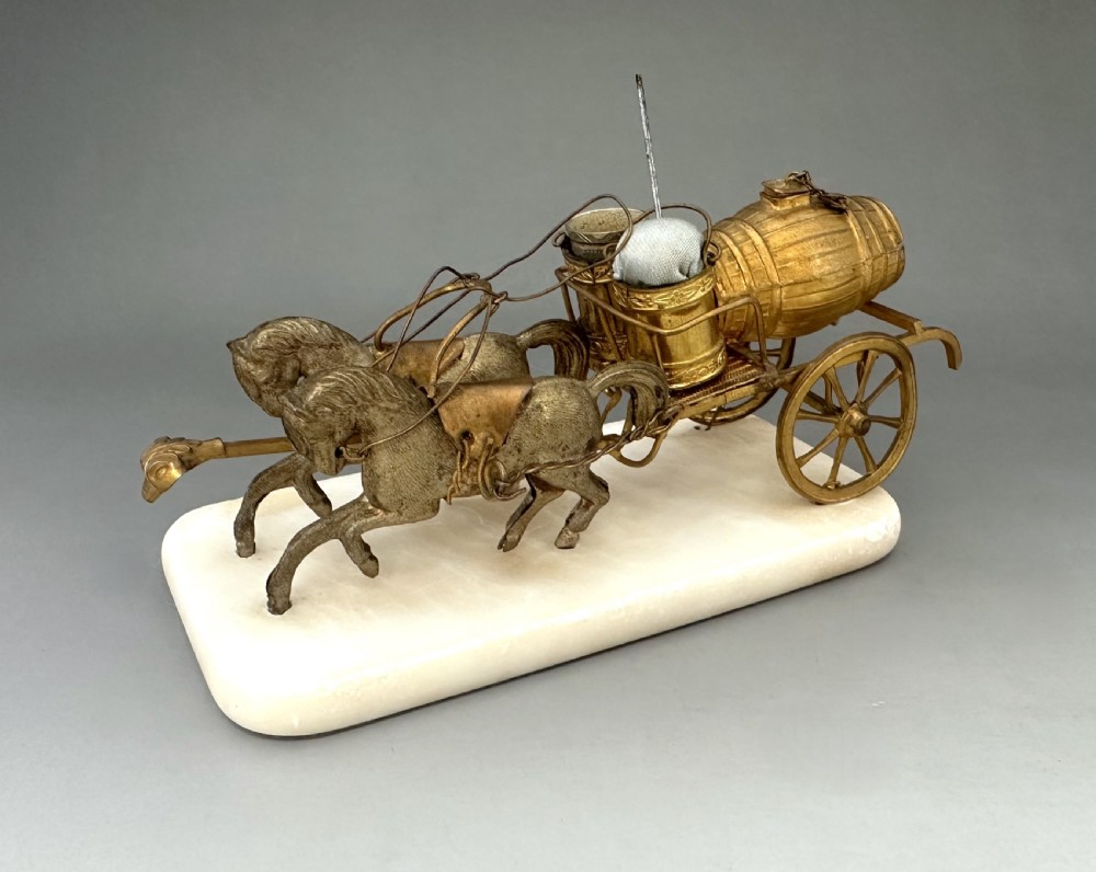 A French Palais Royal gilt metal horse-drawn carriage sewing companion mounted on a white alabaster base.