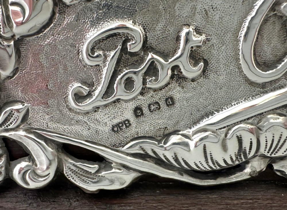 An Edwardian wooden postcard holder featuring an intricate repousse silver mount embossed with the words Post Cards. View VII