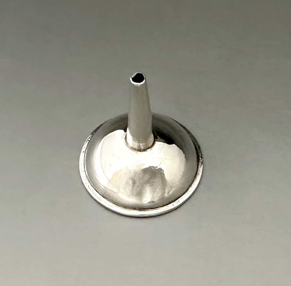 An Old Sheffield plate silver perfume funnel featuring a conical bowl and a narrow tapered spout resting upright. View II