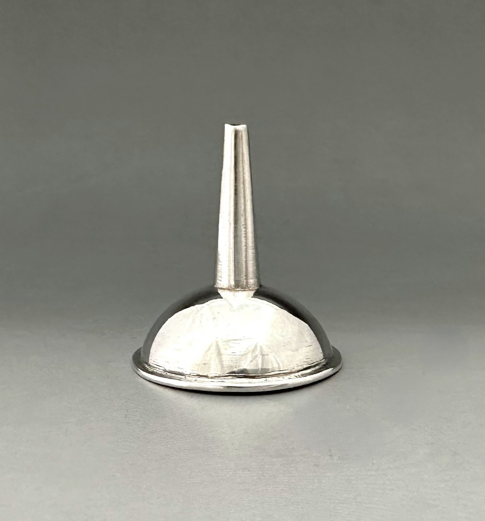 An Old Sheffield plate silver perfume funnel featuring a conical bowl and a narrow tapered spout resting upright. View VI