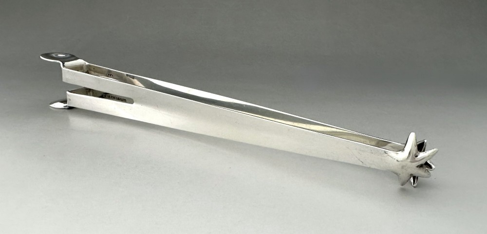 A pair of polished silver Edwardian bar tongs featuring slender arms with mechanical claw gripping ends and flat finger pads. View IV