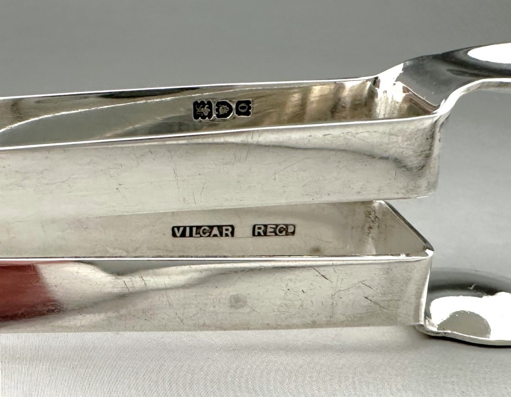 A pair of polished silver Edwardian bar tongs featuring slender arms with mechanical claw gripping ends and flat finger pads. View VII