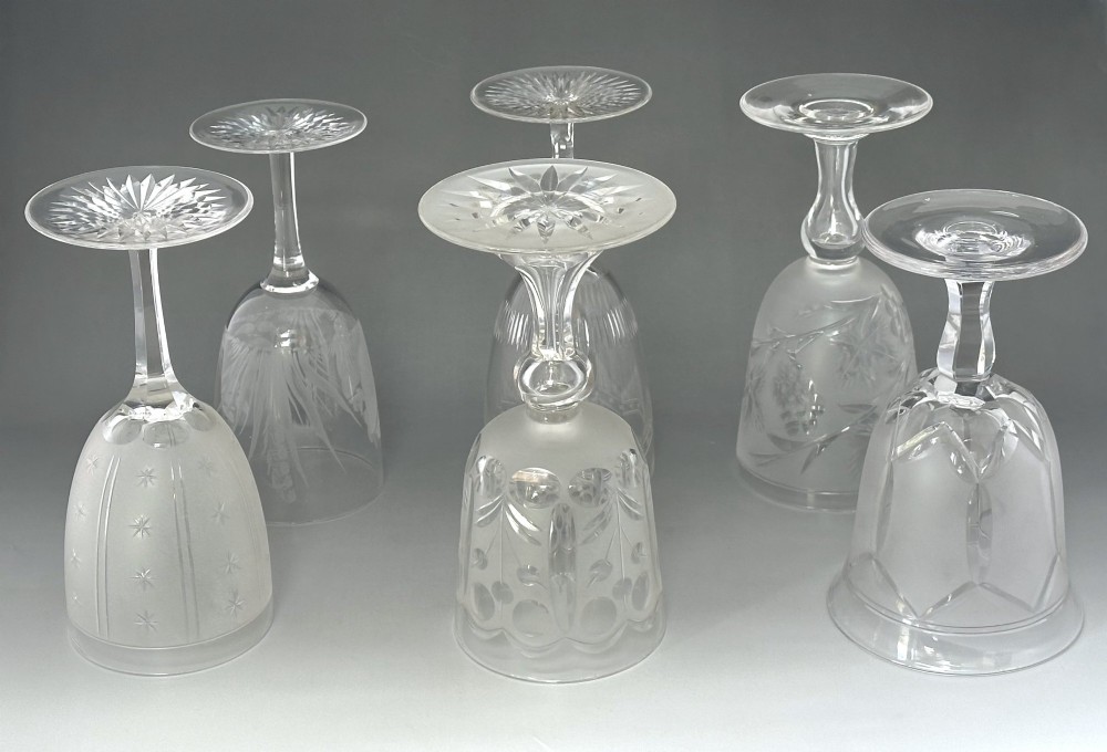 A set of six clear Victorian glass goblets, each featuring distinct hand-etched and cut geometric and floral patterns. View II