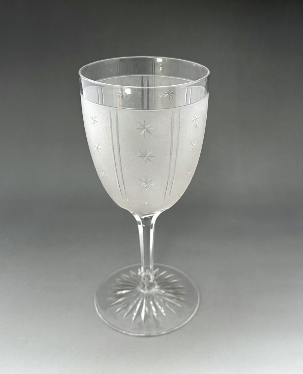 A set of six clear Victorian glass goblets, each featuring distinct hand-etched and cut geometric and floral patterns. View III