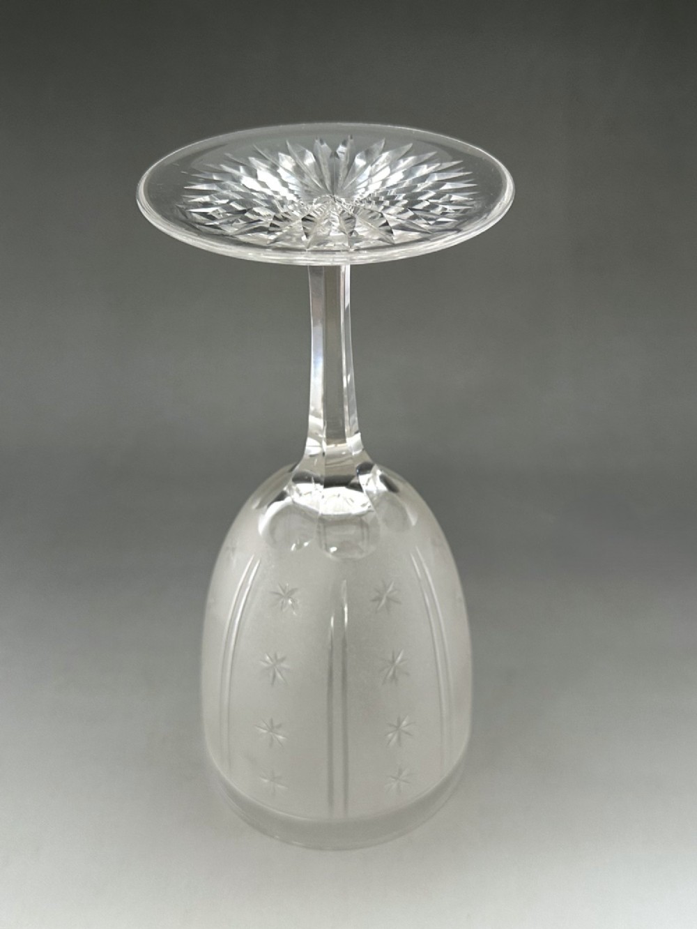 A set of six clear Victorian glass goblets, each featuring distinct hand-etched and cut geometric and floral patterns. View IV