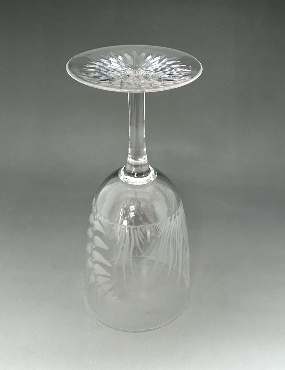 A set of six clear Victorian glass goblets, each featuring distinct hand-etched and cut geometric and floral patterns. View VI