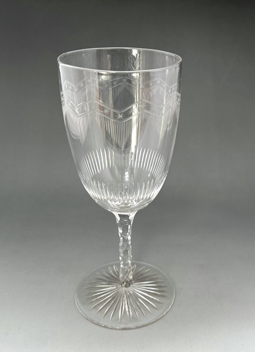 A set of six clear Victorian glass goblets, each featuring distinct hand-etched and cut geometric and floral patterns. View VII