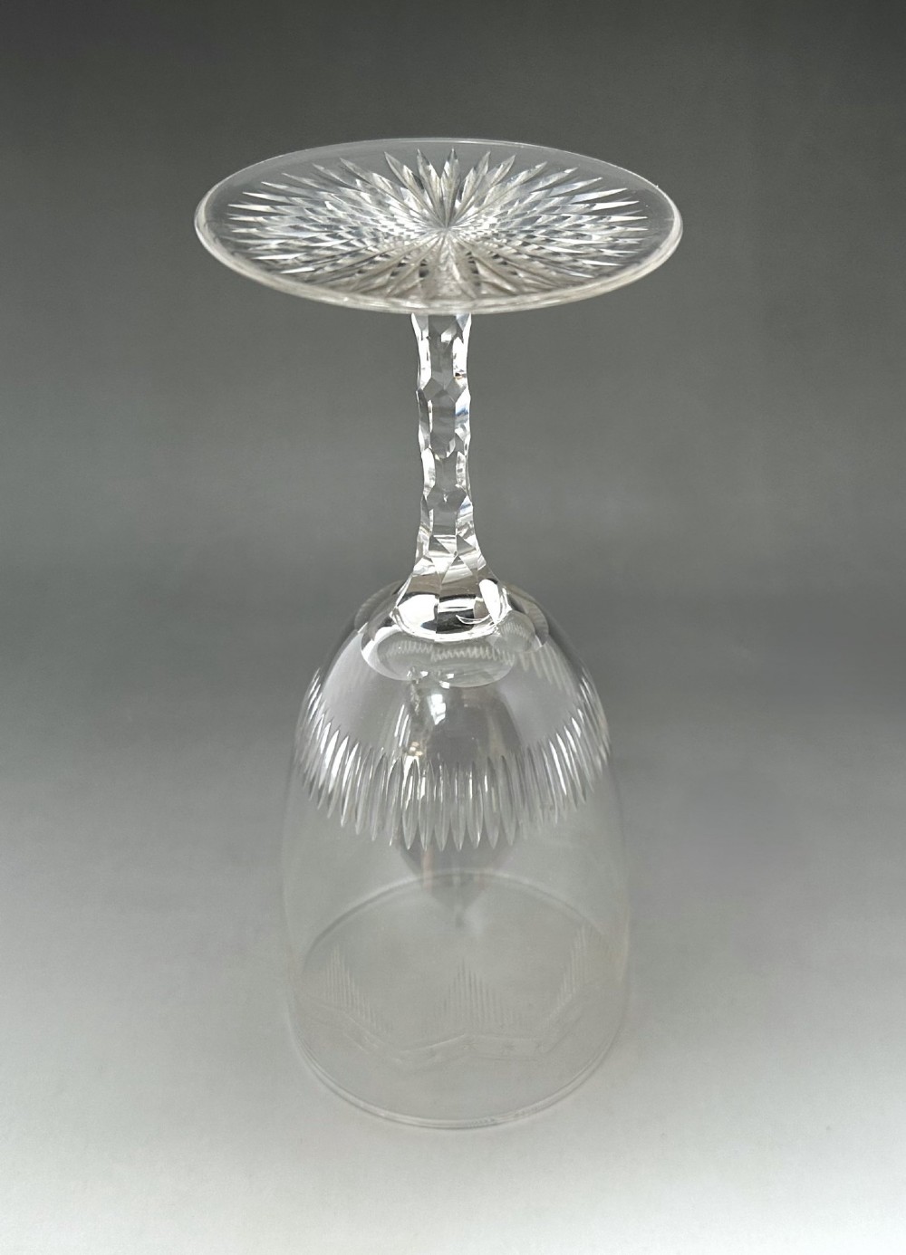 A set of six clear Victorian glass goblets, each featuring distinct hand-etched and cut geometric and floral patterns. View VIII