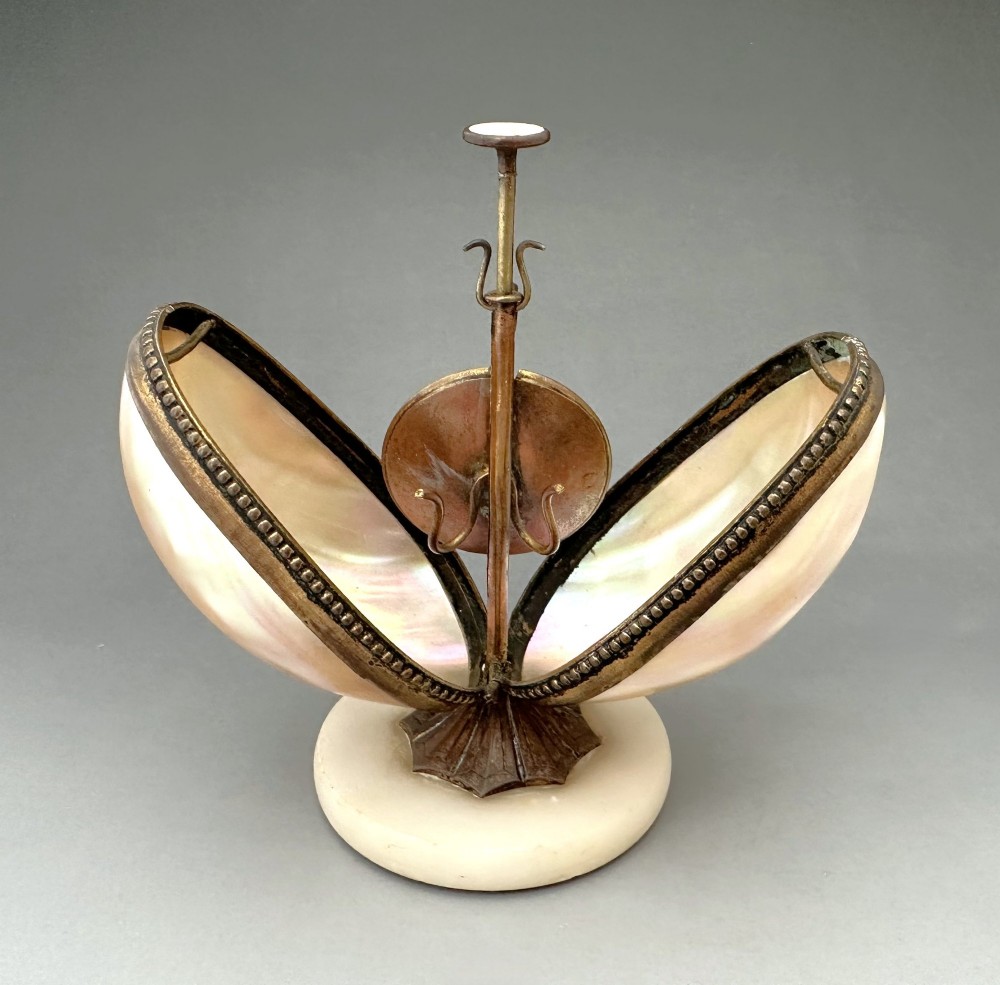 An open French Palais Royal mother-of-pearl egg-shaped etui featuring gilt bronze trim, a green velvet central cushion, and a round alabaster base. View IV