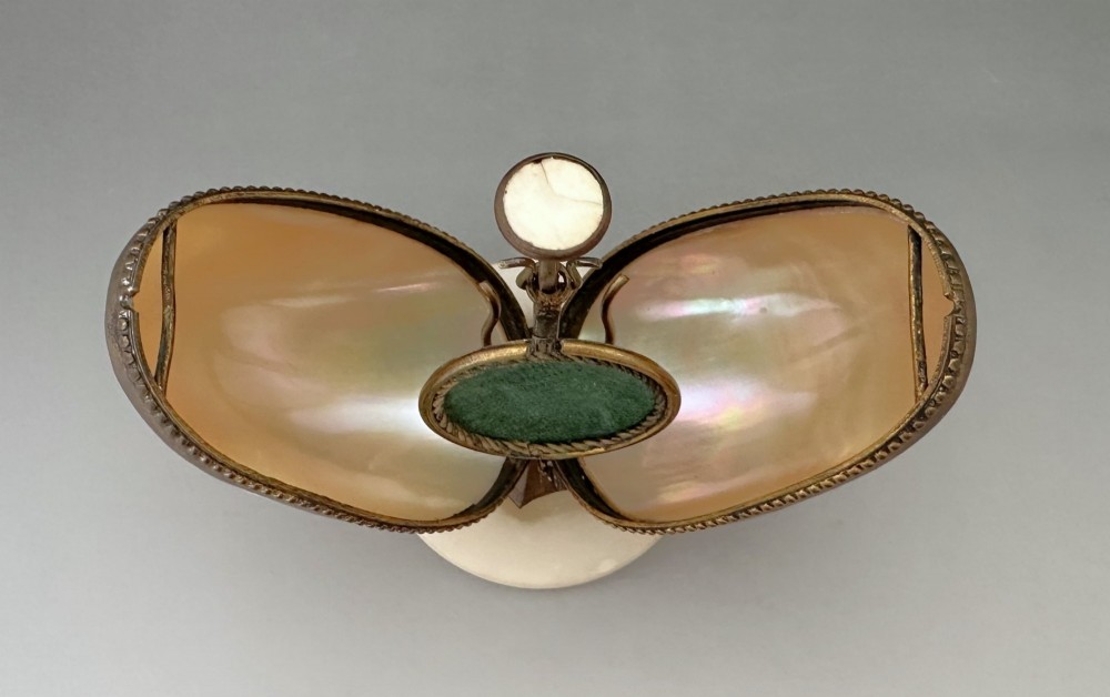 An open French Palais Royal mother-of-pearl egg-shaped etui featuring gilt bronze trim, a green velvet central cushion, and a round alabaster base. View VI